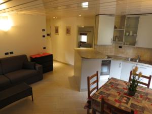 a kitchen and living room with a table and a couch at Baita Li Selucia in Livigno