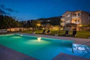 米尼亚Queen Bee Residence的夜晚房子前的游泳池