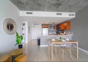 eine Küche und ein Esszimmer mit einem Tisch und Stühlen in der Unterkunft Cozy 2BR Family Apt With Pool At Midblock Miami in Miami