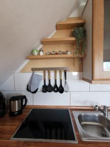 een keuken met een wastafel en een aanrecht met keukengerei bij 2,5 Zimmer Wohnung Hennef Nähe Siebengebirge in Uckerath