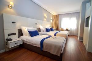 a hotel room with two beds and a window at Mitte Port Hotel Konak Izmir in Izmir