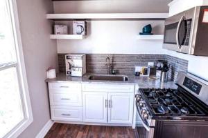 una cucina con mobili bianchi e un forno a piano cottura di Luxury House Medical Center/Downtown/EV/Parking a Houston