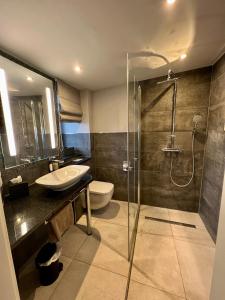 a bathroom with a shower and a sink and a toilet at Hotel Belvedere in Warnemünde