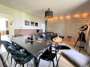 een woonkamer met een tafel en stoelen en een bank bij Le Neufchâtel appartement cosy 3 chambres in Reims