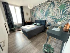 - une chambre avec un lit et une table dans l'établissement Le Neufchâtel appartement cosy 3 chambres, à Reims