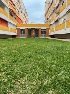 an empty courtyard of a building with green grass at Apartamento Portisol in El Portil