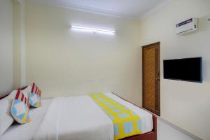 a bedroom with a bed and a flat screen tv at Hotel Yadvik in Chennai