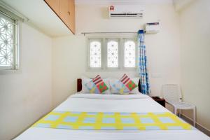 a bedroom with a bed and a window at Hotel Yadvik in Chennai