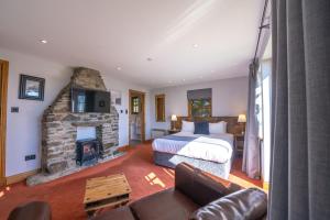 a bedroom with a bed and a stone fireplace at Oak Tree Inn in Balmaha