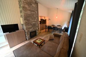 - un salon avec un canapé et une cheminée en pierre dans l'établissement Rabais 75, à Virton