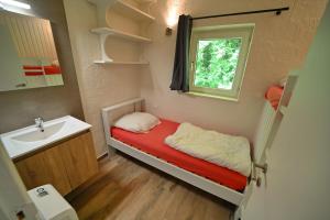 mały pokój z łóżkiem i umywalką w obiekcie Rabais 75 w mieście Virton