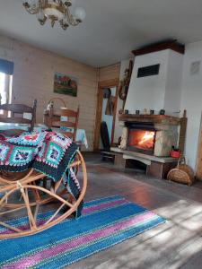 ein Wohnzimmer mit einem Kamin, einem Tisch und Stühlen in der Unterkunft Agroturystyka LipoweWzgórze domek Danusia in Tereszpol