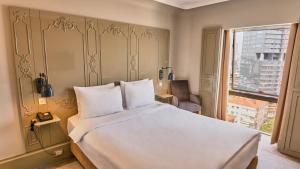 a bedroom with a large white bed and a window at The Cettia Istanbul in Istanbul