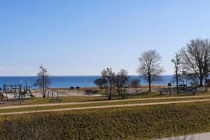 einen Park mit Spielplatz mit dem Ozean im Hintergrund in der Unterkunft Kaiserhof Oceanview in Kellenhusen + 3 Fotos