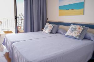 a bedroom with a bed with white sheets and pillows at Balcon del Mar in Puerto Rico de Gran Canaria +32 photos