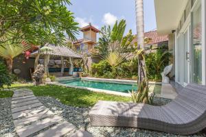 a backyard with a swimming pool and a house at Villa Maloa in Denpasar