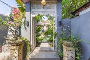 an entrance to a house with a blue door and potted plants at Villa Maloa in Denpasar