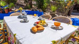 einen Tisch mit einem weißen Tischtuch mit Essen drauf in der Unterkunft Casa Mulera Alozaina by Ruralidays in Alozaina