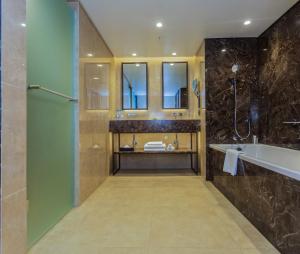 a bathroom with a shower and a tub and a sink at InterContinental Lusaka, an IHG Hotel in Lusaka