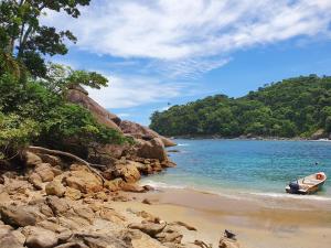 a boat sitting on the shore of a beach at Pousada Korui in Abraão