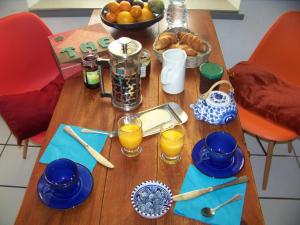 einen Holztisch mit Frühstückszutaten und Orangensaft in der Unterkunft Grande maison atypique in Le Burgaud