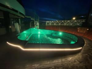 una piscina por la noche con luces verdes en Alisa Cruise Halong, en Ha Long