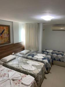 a hotel room with three beds in a room at Pousada Orla dos Corais in Maragogi