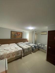 Un grupo de 4 camas en una habitación en Pousada Orla dos Corais, en Maragogi