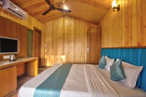 a bedroom with a large bed in a wooden room at Oceano Beach Resort in Arambol