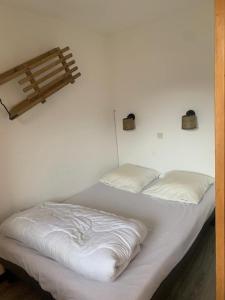 a white bed with two pillows on top of it at Cosy Val Tho ski aux pieds in Val Thorens