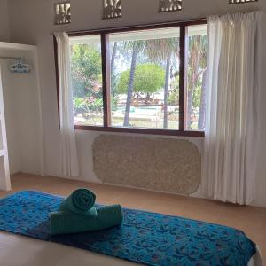 um quarto com uma cama e uma grande janela em Juliantos by the sea em Gili Air
