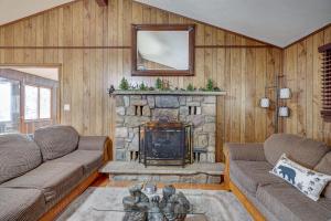a living room with a couch and a stone fireplace at Bear Haven Cabin - Ski/Lake/Pool with Game Room! in Gouldsboro