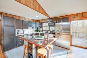 una cocina con electrodomésticos de acero inoxidable y armarios de madera en Bear Haven Cabin - Lake, AC, Pool with Game Room!, en Gouldsboro
