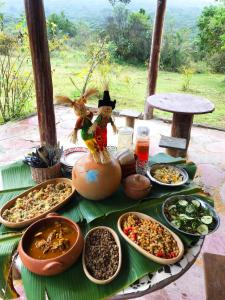 a table with many different dishes of food on it at Pousada Pé do Morro in Vale do Capao