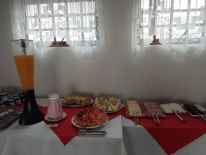 a table with two plates of food and a drink at Hotel Guarini in Monte Sião