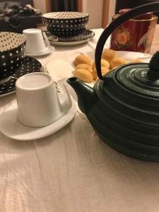 Appartamento nel Borgo في روفيريتو: طاولة مع وعاء الشاي والبسكويت عليها