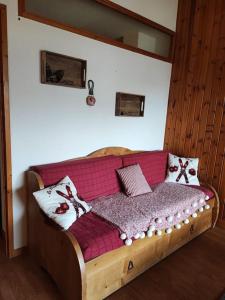 - un lit en bois avec des oreillers dans l'établissement Appartement 4 personnes Puy Saint Vincent 1800 pieds des pistes, à Puy-Saint-Vincent