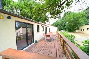 une terrasse en bois avec une table et des chaises. dans l'établissement Rabais 57-58, à Virton