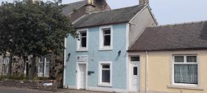 a blue house on the side of a street at Irvine Riverside Guesthouse by Paymán Club in Irvine