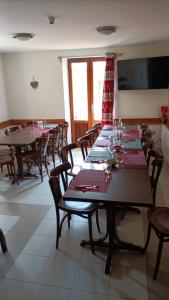 a large dining room with tables and chairs and a television at Auberge l'écureuil in Châteauneuf-dʼEntraunes