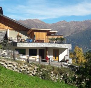 a house on a hill with mountains in the background at Hofstatthof in Campo di Trens