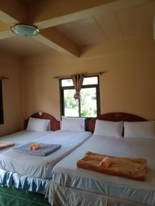 two beds sitting next to each other in a room at Charung Beach in Haad Rin