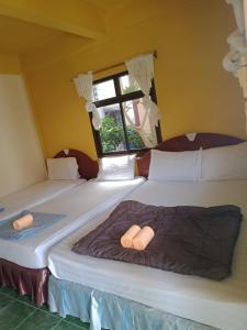 two twin beds in a room with a window at Charung Beach in Haad Rin