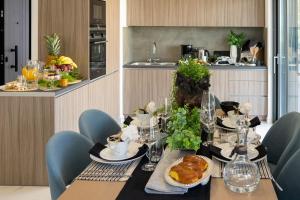 ein Esszimmer mit einem Tisch mit Essen drauf in der Unterkunft The Lop Athens Holidays Luxury Suites in Athen