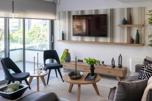A television and/or entertainment centre at The Lop Athens Holidays Luxury Suites
