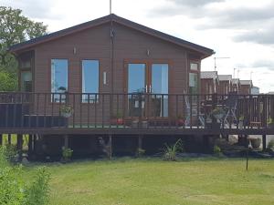 een huis op een terras met een veranda bij Kingfisher Lodge in Felton