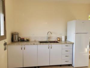 a kitchen with white cabinets and a white refrigerator at Home away from home in Safed