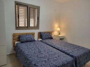 a bedroom with two beds and a window at Home away from home in Safed