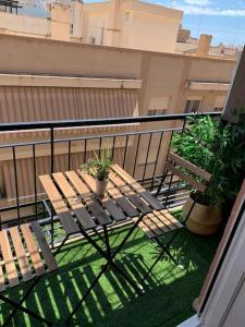 balcón con mesa de madera y 2 macetas en Apartamento Oasis Mediterráneo en San Vicente del Raspeig