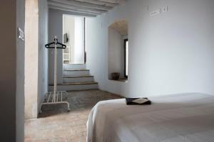 ein weißes Zimmer mit einem Bett und einer Treppe in der Unterkunft Apartamento La Casa del Santo in Carmona